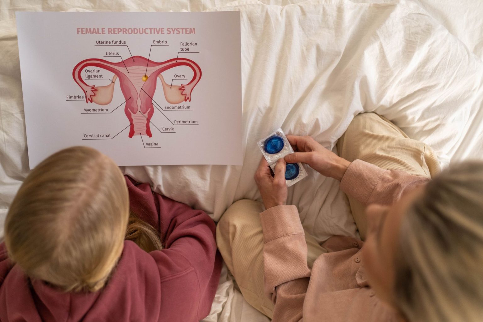 Mulher adulta conversa com uma jovem sobre saúde reprodutiva e métodos contraceptivos em um ambiente de atendimento.