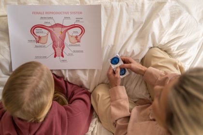 Mulher adulta conversa com uma jovem sobre saúde reprodutiva e métodos contraceptivos em um ambiente de atendimento.