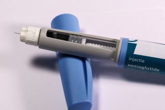 Caneta de aplicação de semaglutida sobre uma superfície branca, em contexto de saúde.